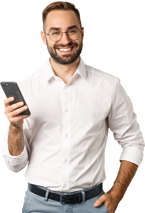 Young, dark-haired, bespectacled salesman smiling with his cell phone in his right hand at half-height